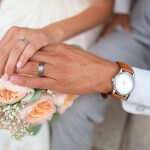 couple having rings in hand and flowers