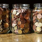 three jars having coins in them